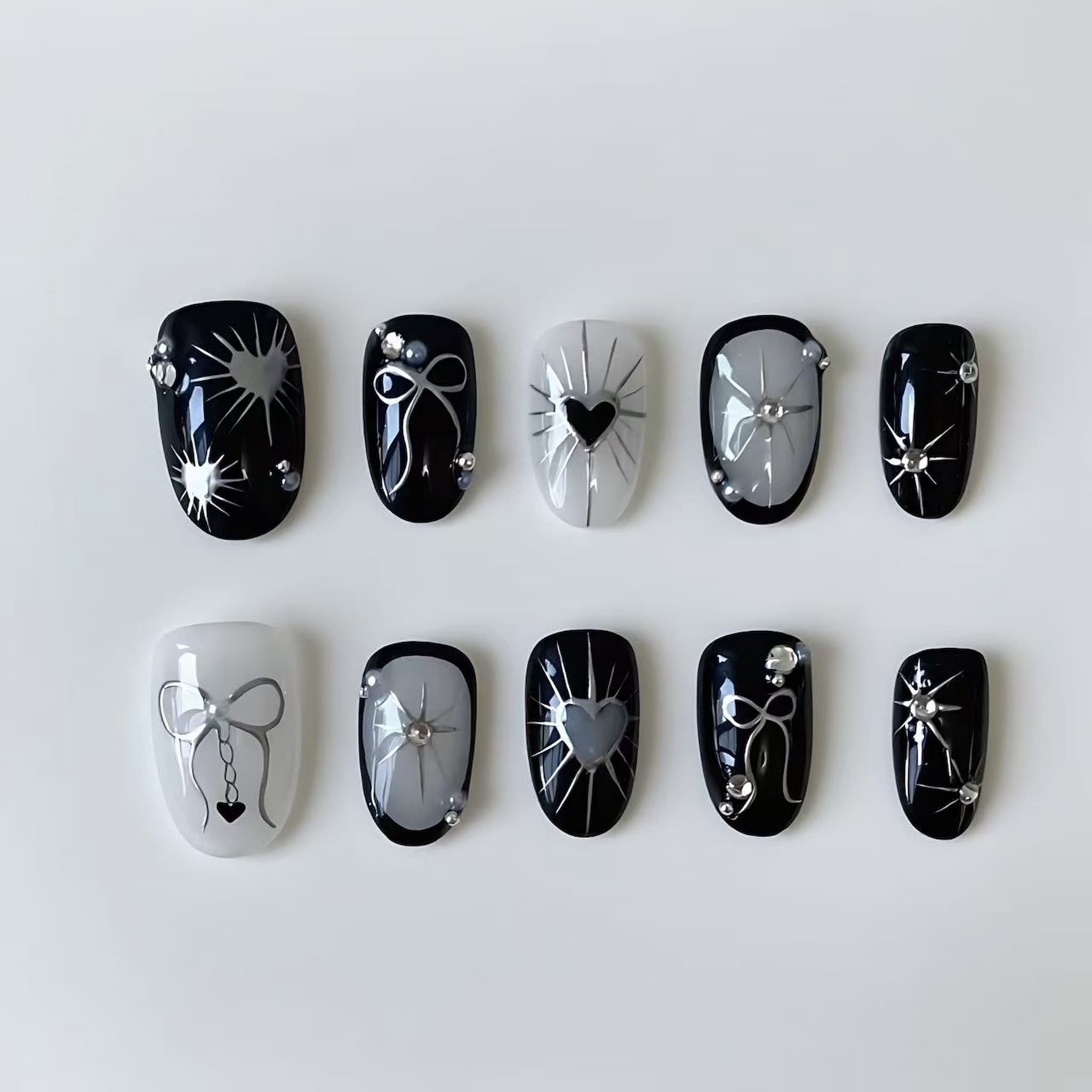 short length black oval press on nails with gothic and heart designs