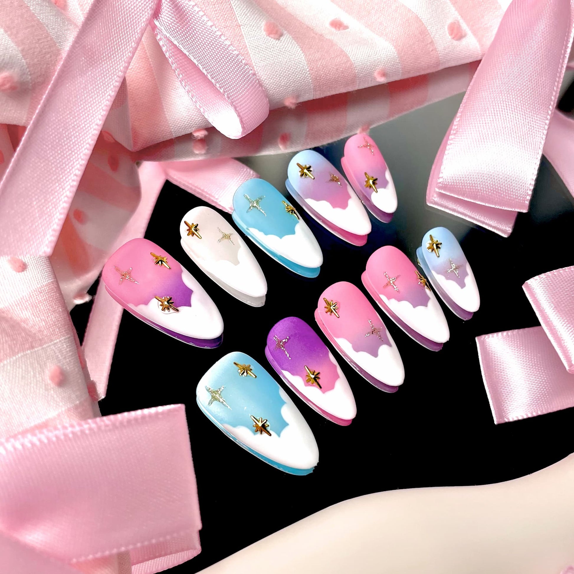medium length light pink almond press on nails with pastel colour palette and stars