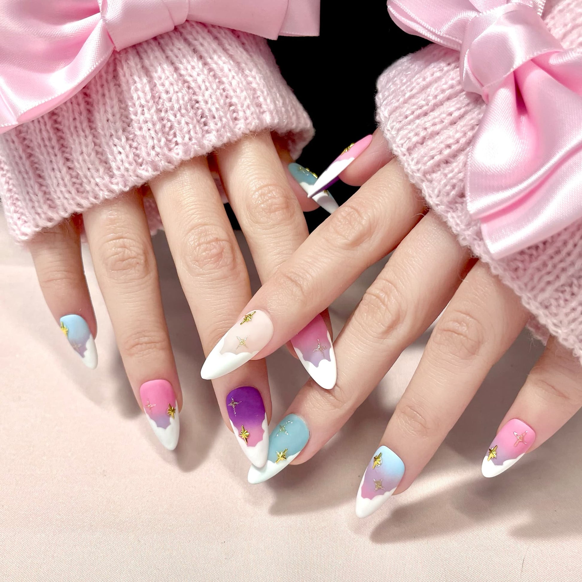 medium length light pink almond press on nails with pastel colour palette and stars
