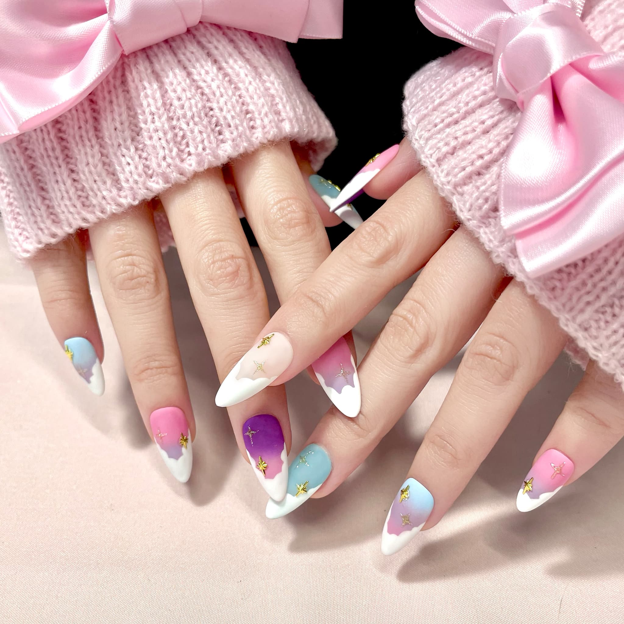 medium length light pink almond press on nails with pastel colour palette and stars