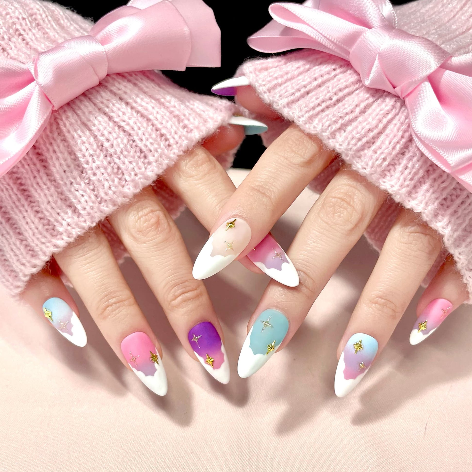 medium length light pink almond press on nails with pastel colour palette and stars