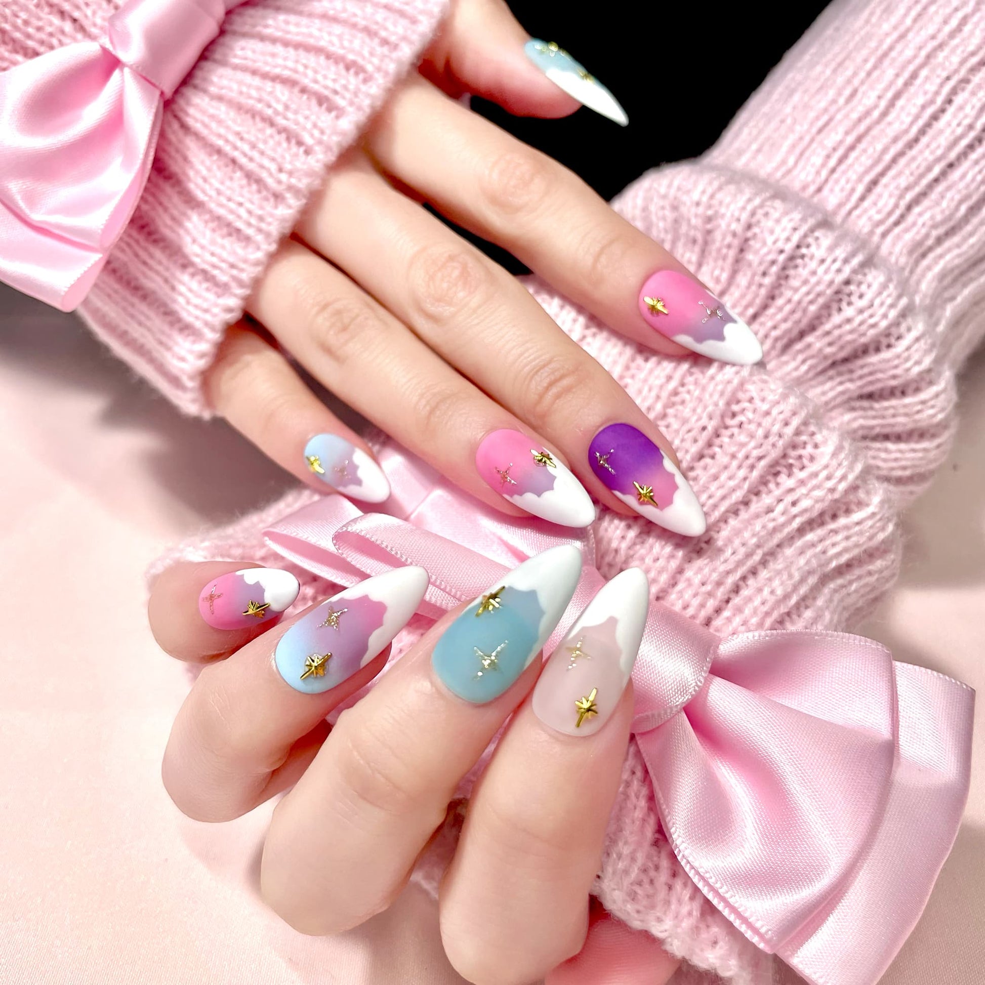 medium length light pink almond press on nails with pastel colour palette and stars