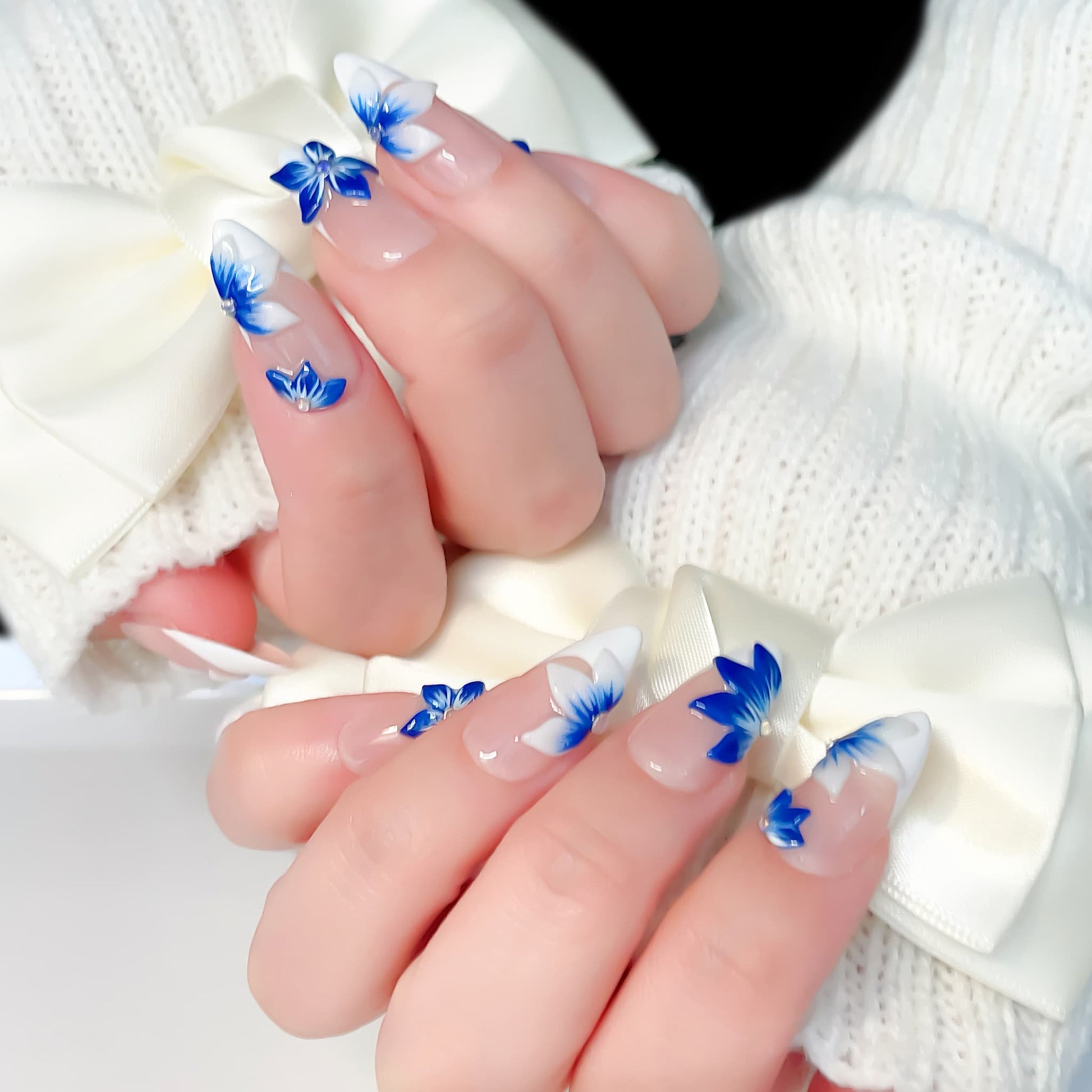 medium length blue almond press on nails with craved flowers design