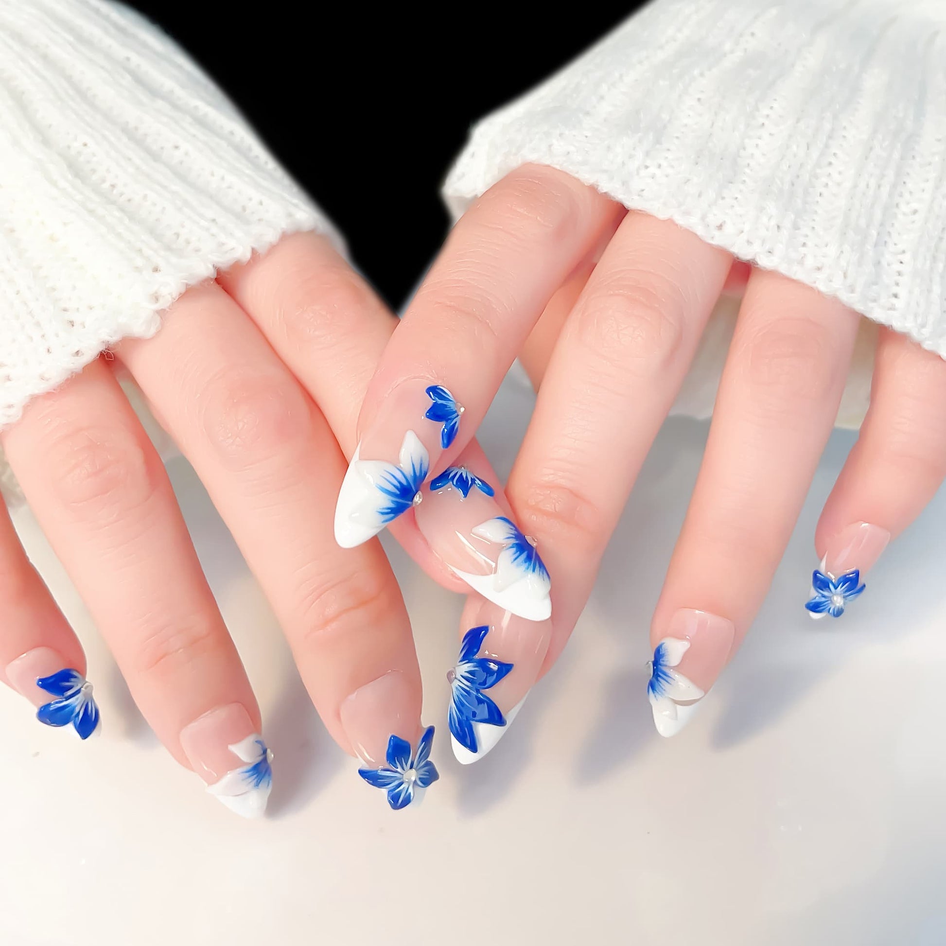 medium length blue almond press on nails with craved flowers design