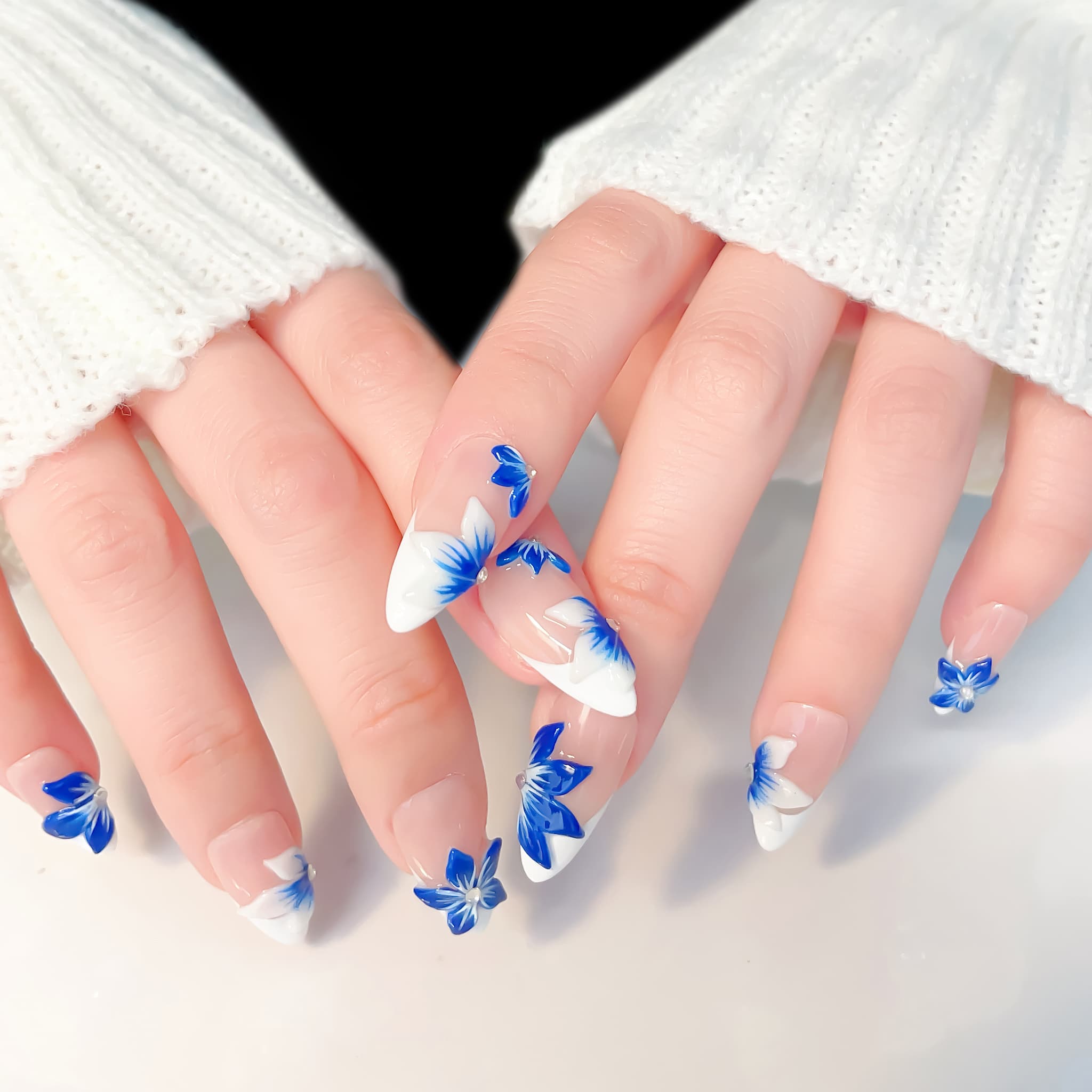 medium length blue almond press on nails with craved flowers design