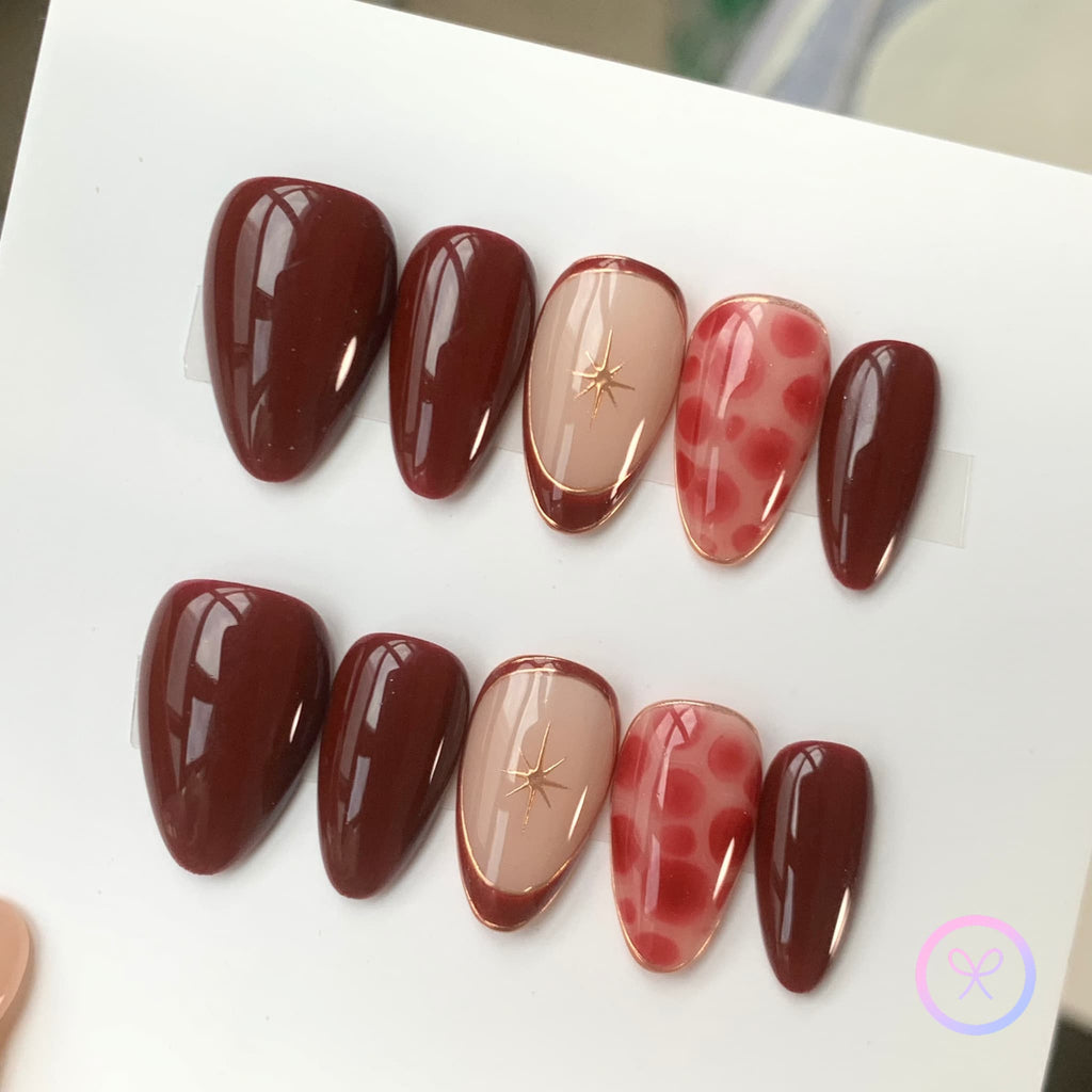 elegant red glossy short almond press on nails with marble motifs and gilded with lined french tips
