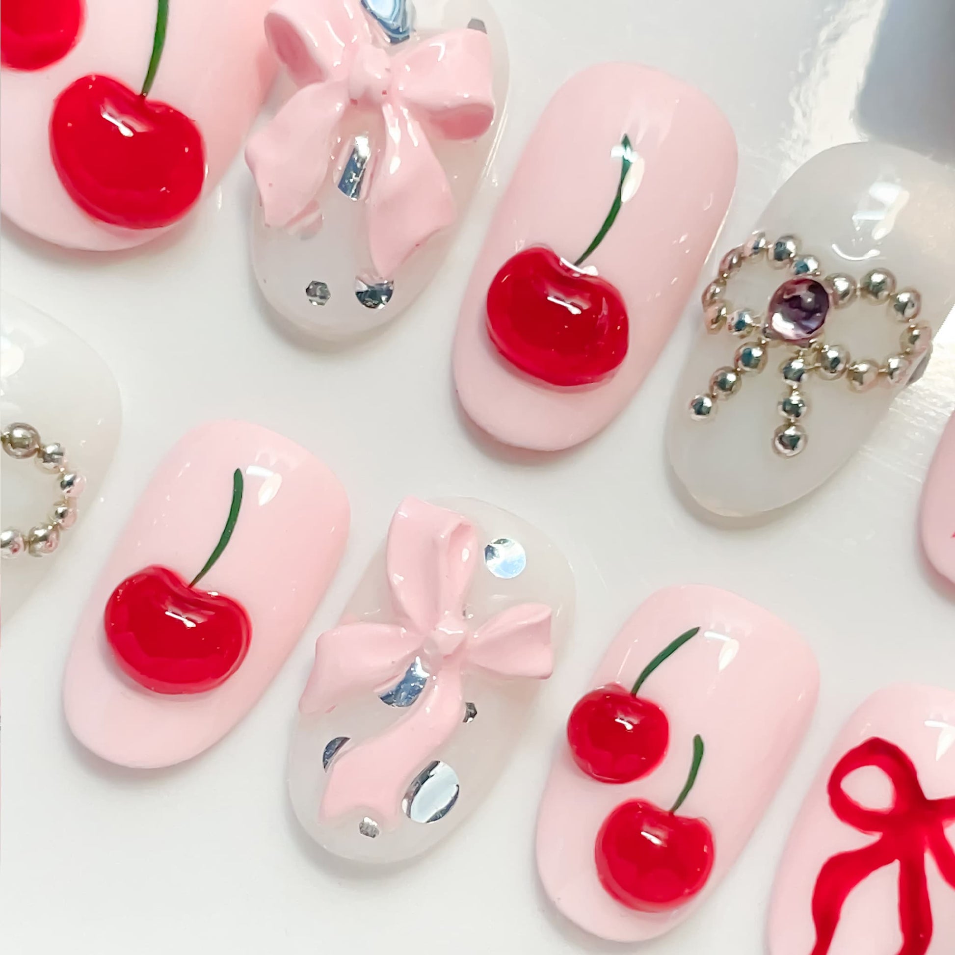 light pink short length oval press on nails with cherries and bows