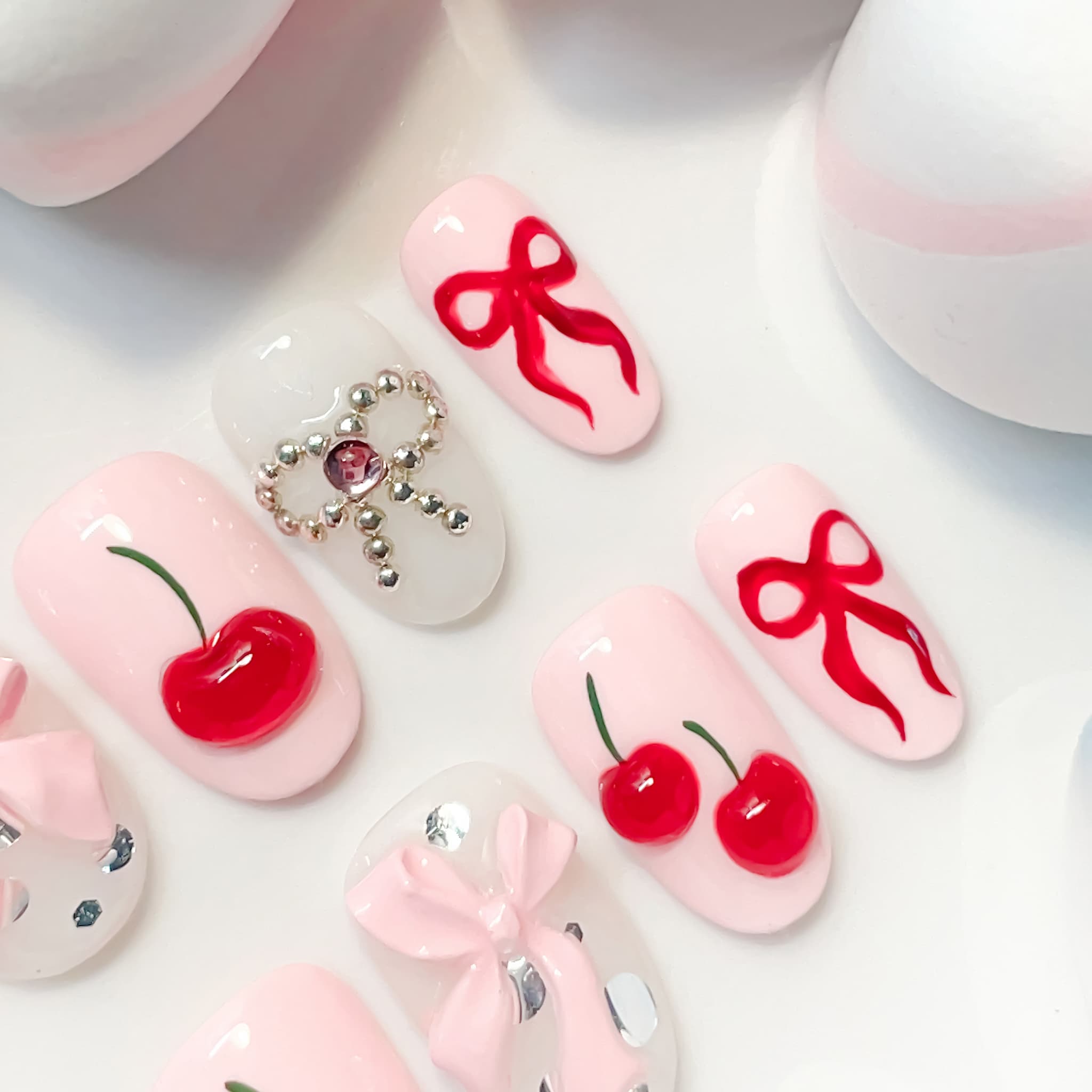 light pink short length oval press on nails with cherries and bows