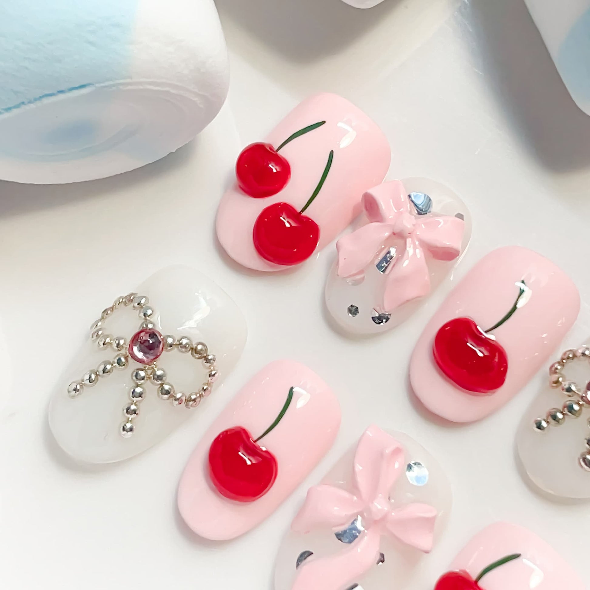 light pink short length oval press on nails with cherries and bows