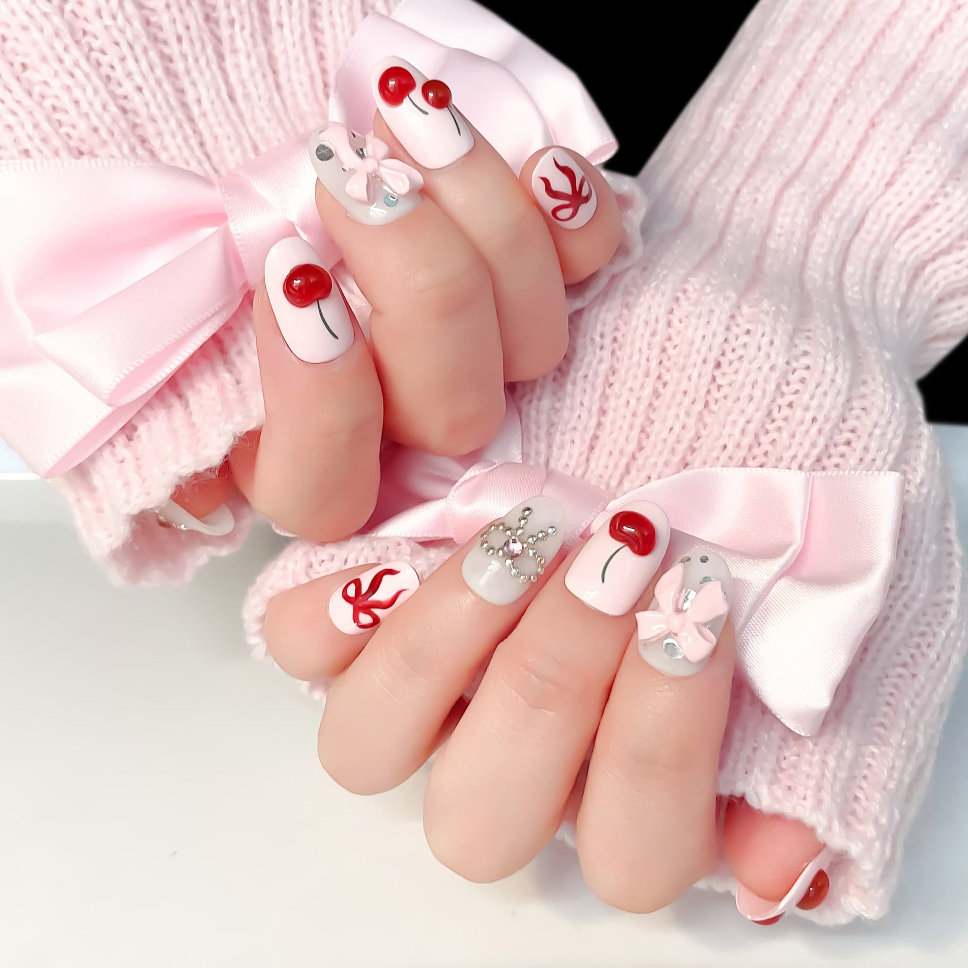 light pink short length oval press on nails with cherries and bows