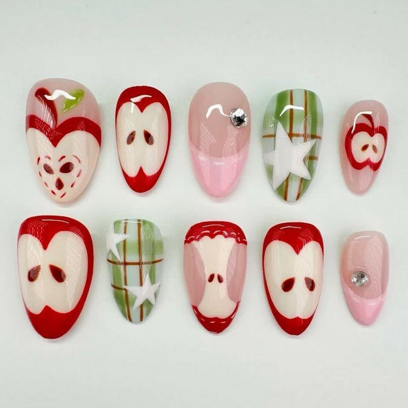 short length red almond press on nails with apple and star designs