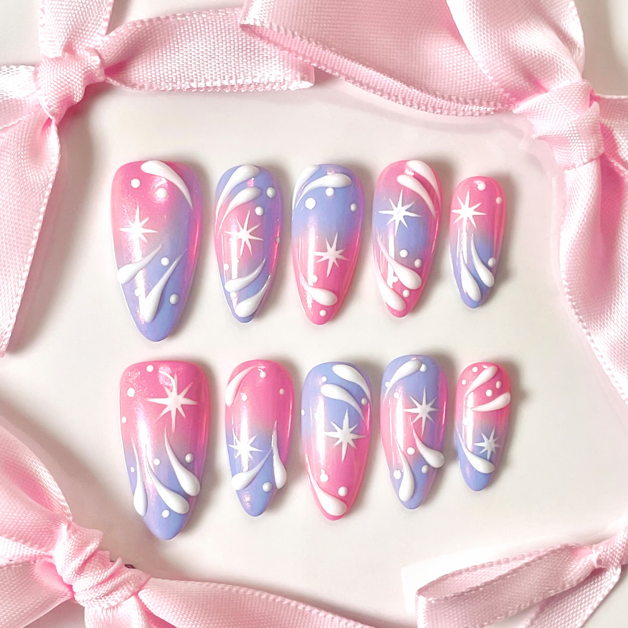 medium length light pink almond press on nails with stars and swirl design