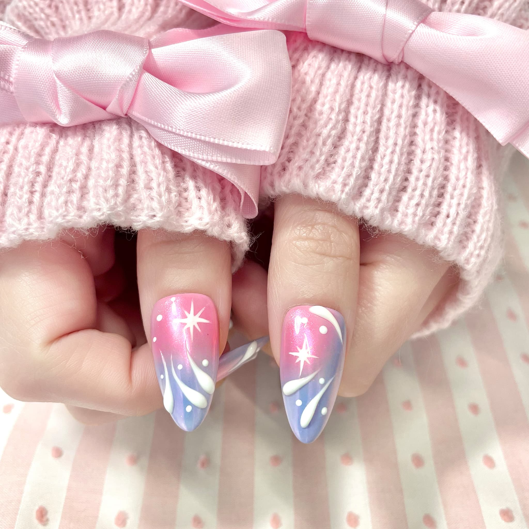 medium length light pink almond press on nails with stars and swirl design