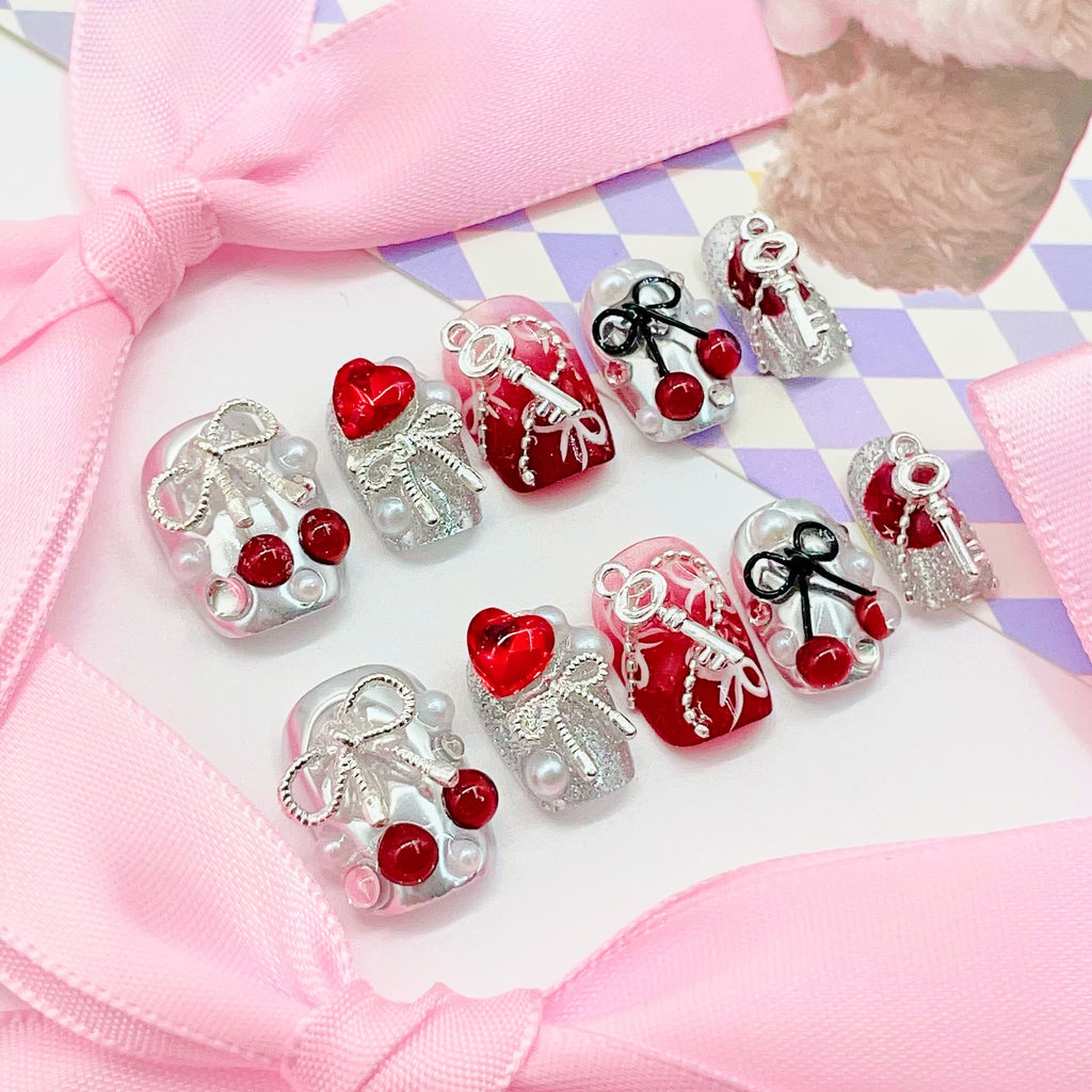 Set of decorative nail art designs with keys, hearts, and bows