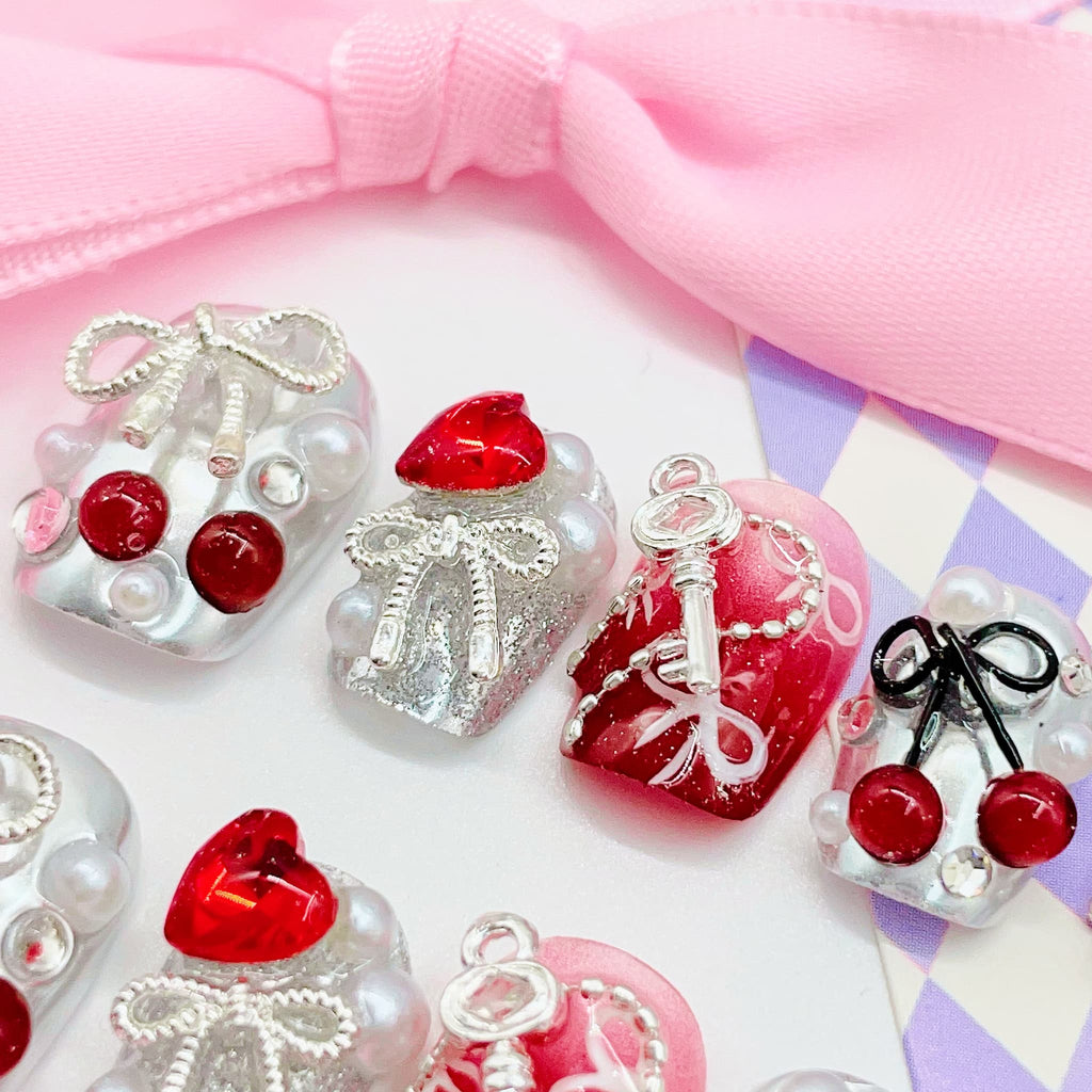 Set of decorative nail art designs with keys, hearts, and bows