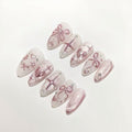 Set of decorative false nails with pink bows and rhinestones on a light background
