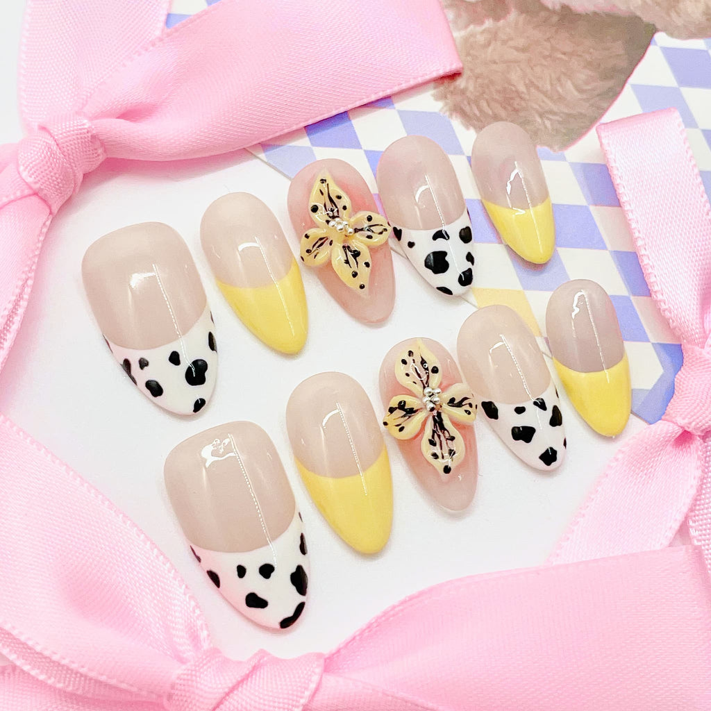 medium length nude almond press on nails with cow animal print design and daisy