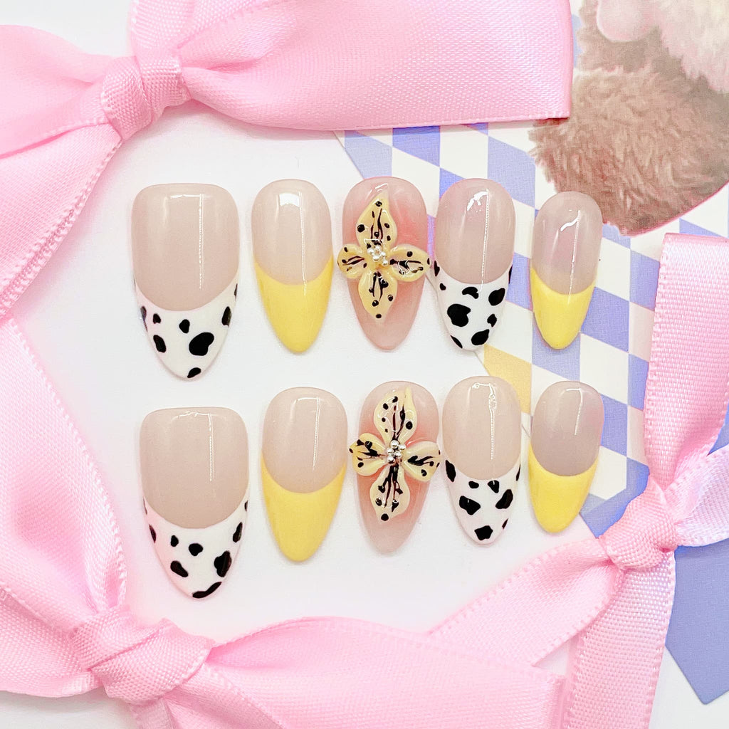 medium length nude almond press on nails with cow animal print design and daisy