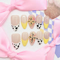 medium length nude almond press on nails with cow animal print design and daisy