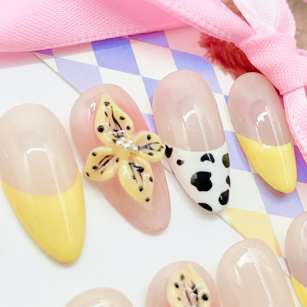 medium length nude almond press on nails with cow animal print design and daisy