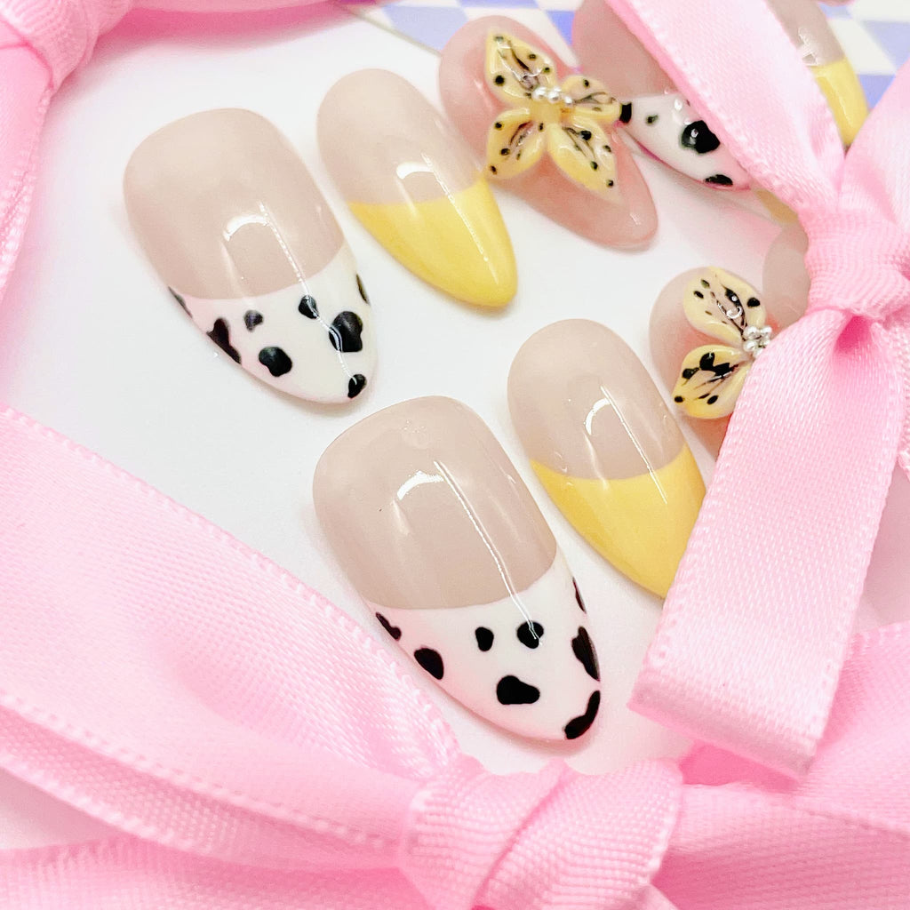 medium length nude almond press on nails with cow animal print design and daisy
