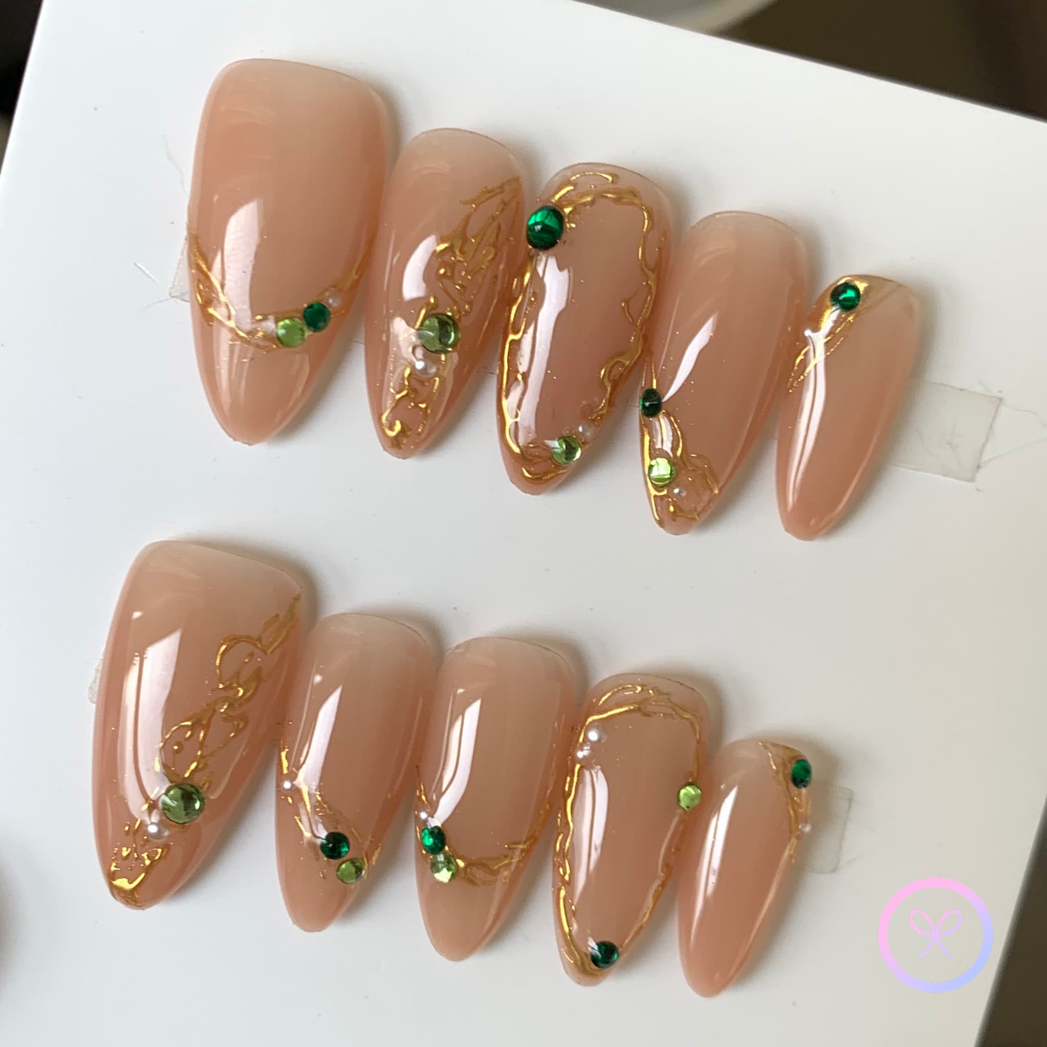 elegant nude glossy medium almond press on nails with filigree and emerald gemstones