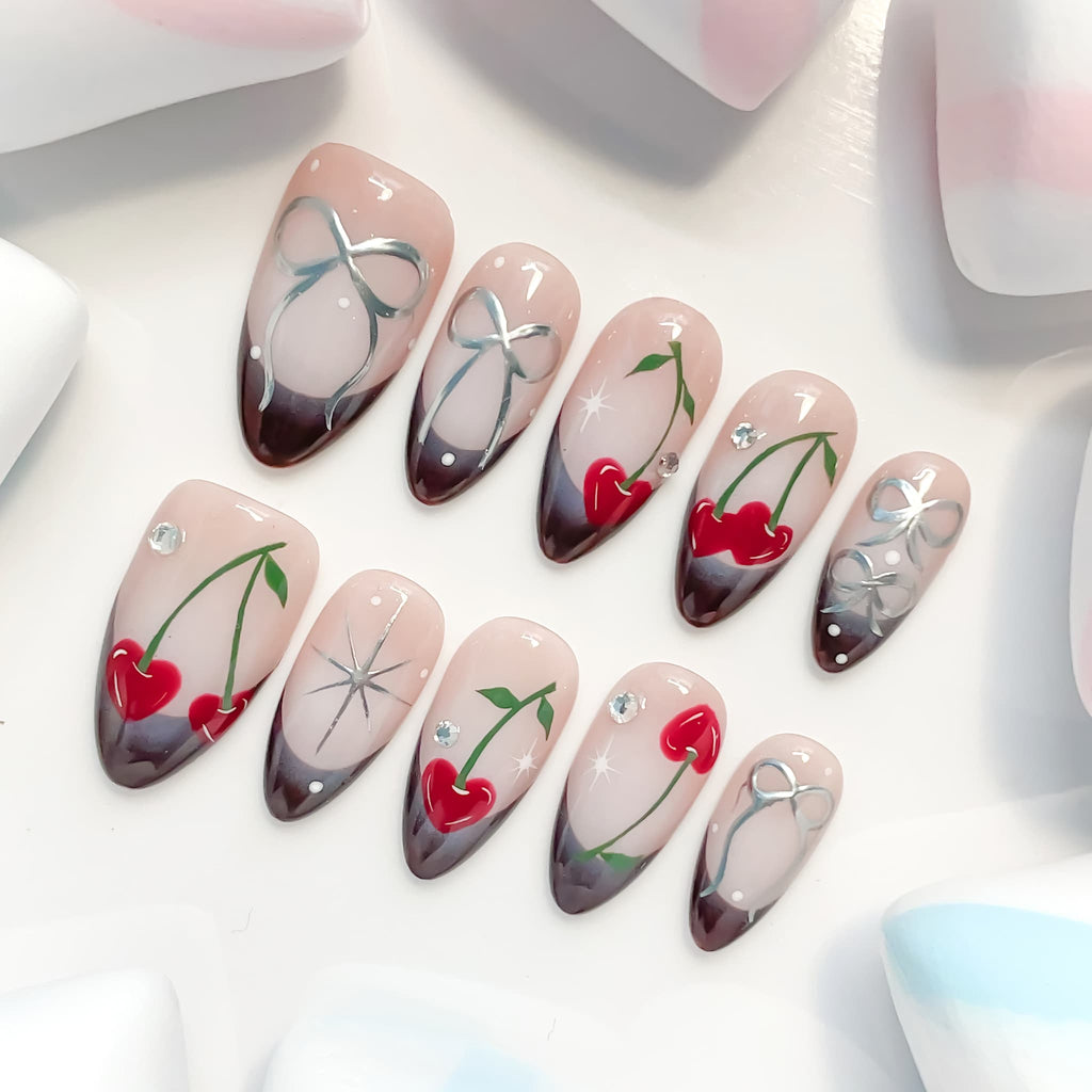 medium length brown almond press on nails with cherry and bow design
