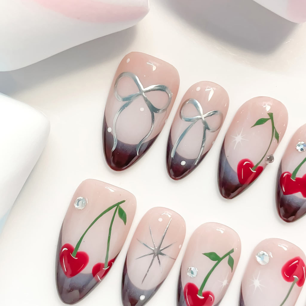 medium length brown almond press on nails with cherry and bow design