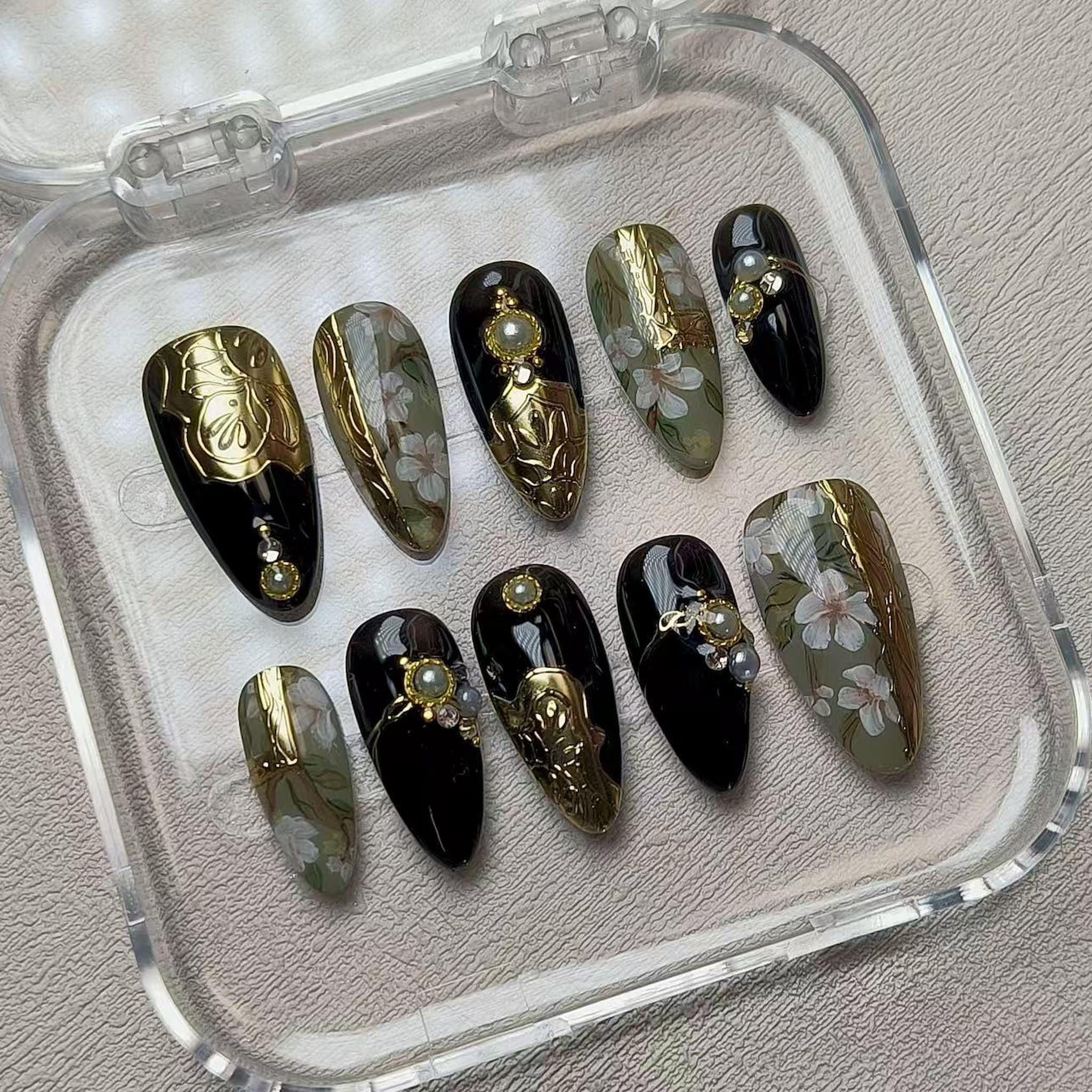 medium length black almond press on nails with golden accent