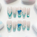 A set of false nails showcasing a mermaid-inspired design with teal colors and glossy finish