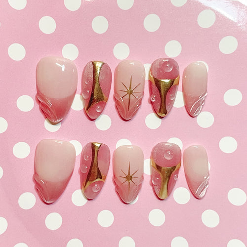 short length misty rose almond press on nails with star design and golden accent