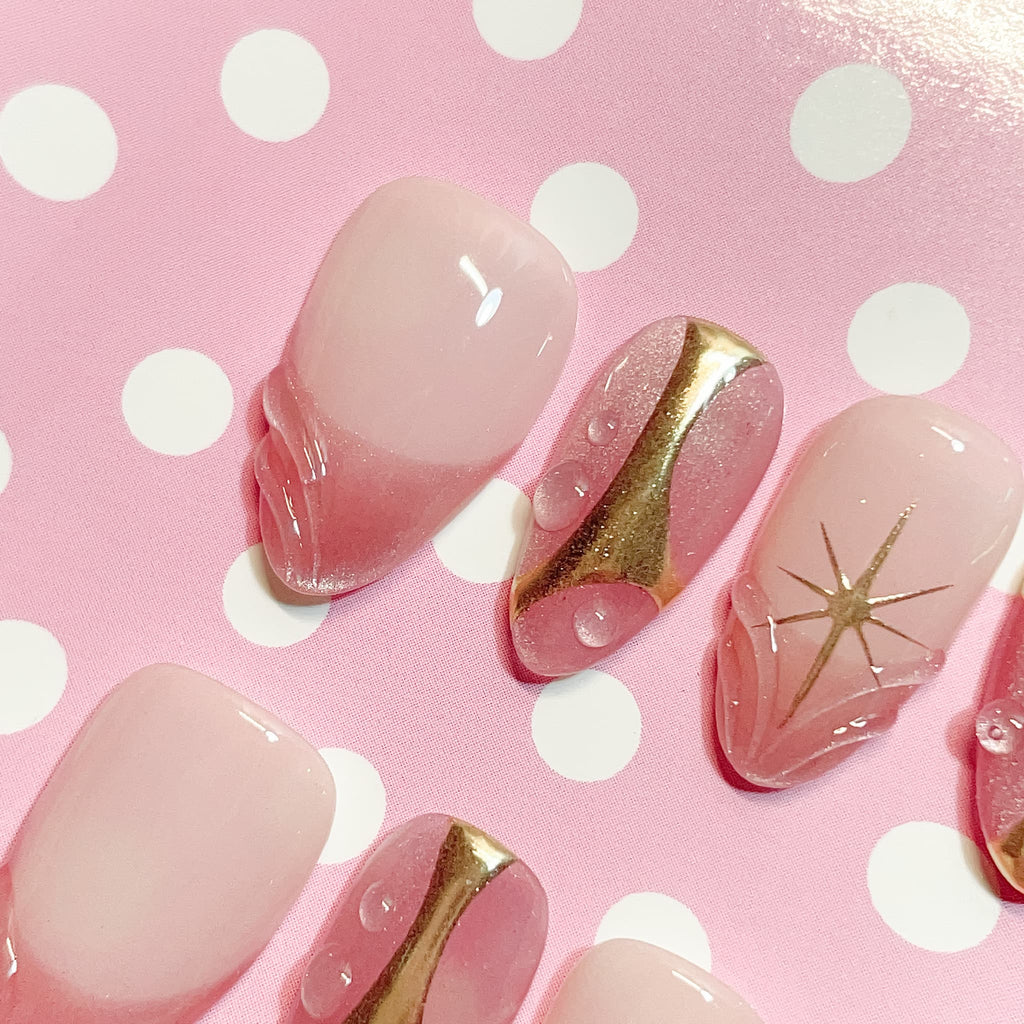 short length misty rose almond press on nails with star design and golden accent