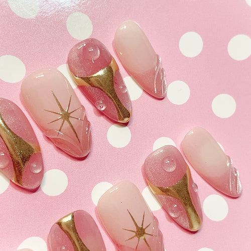 short length misty rose almond press on nails with star design and golden accent