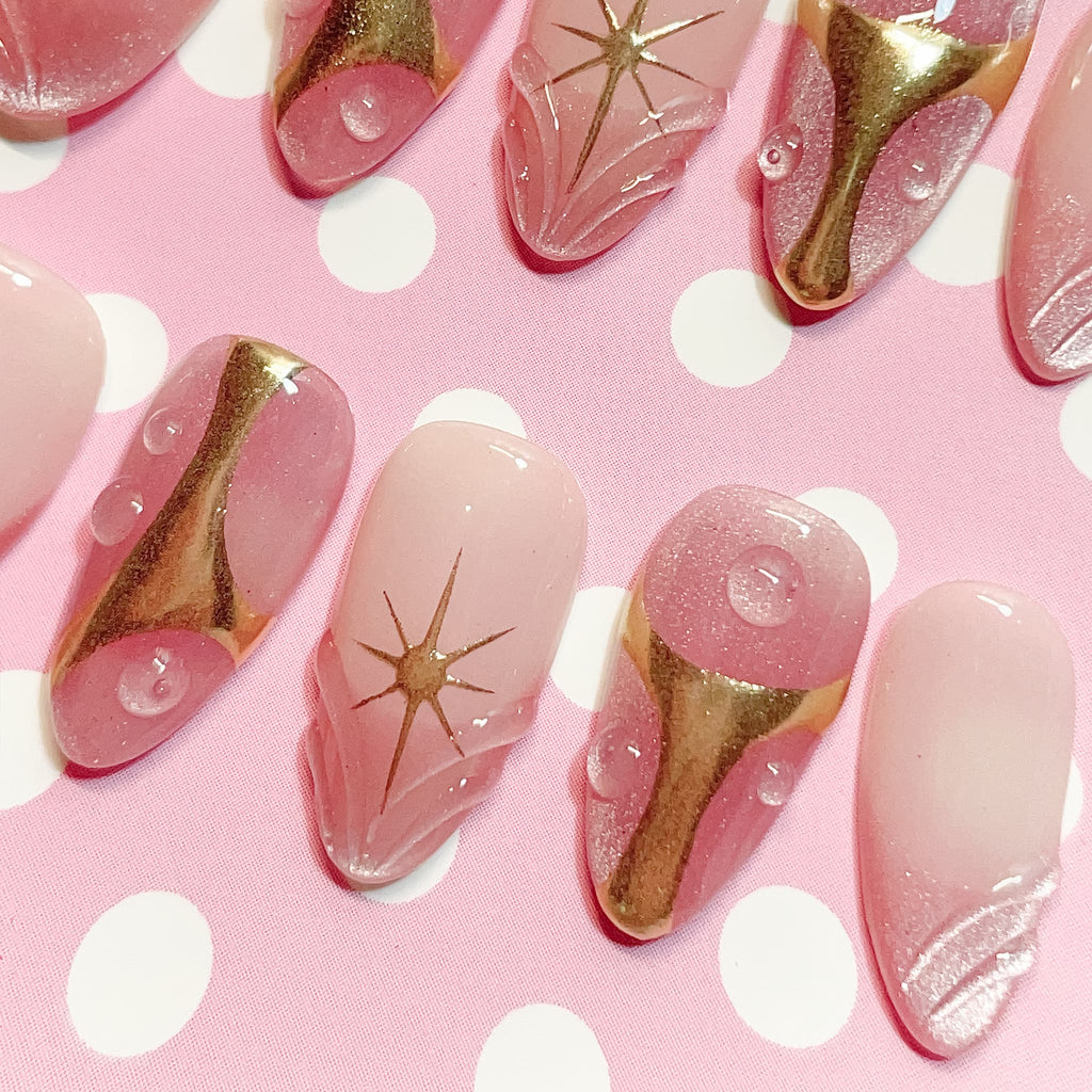 short length misty rose almond press on nails with star design and golden accent