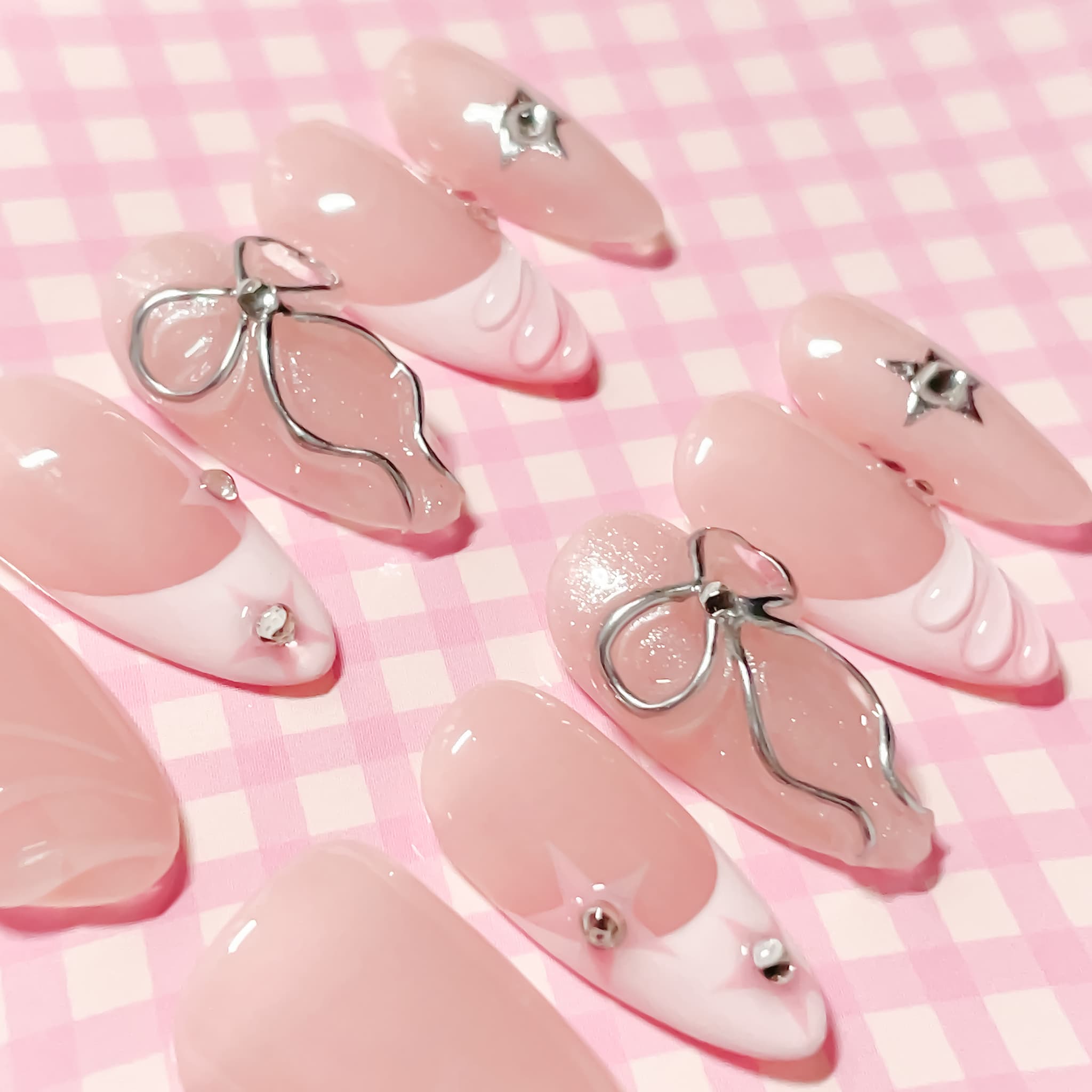 medium length light pink almond press on nails with bows and stars