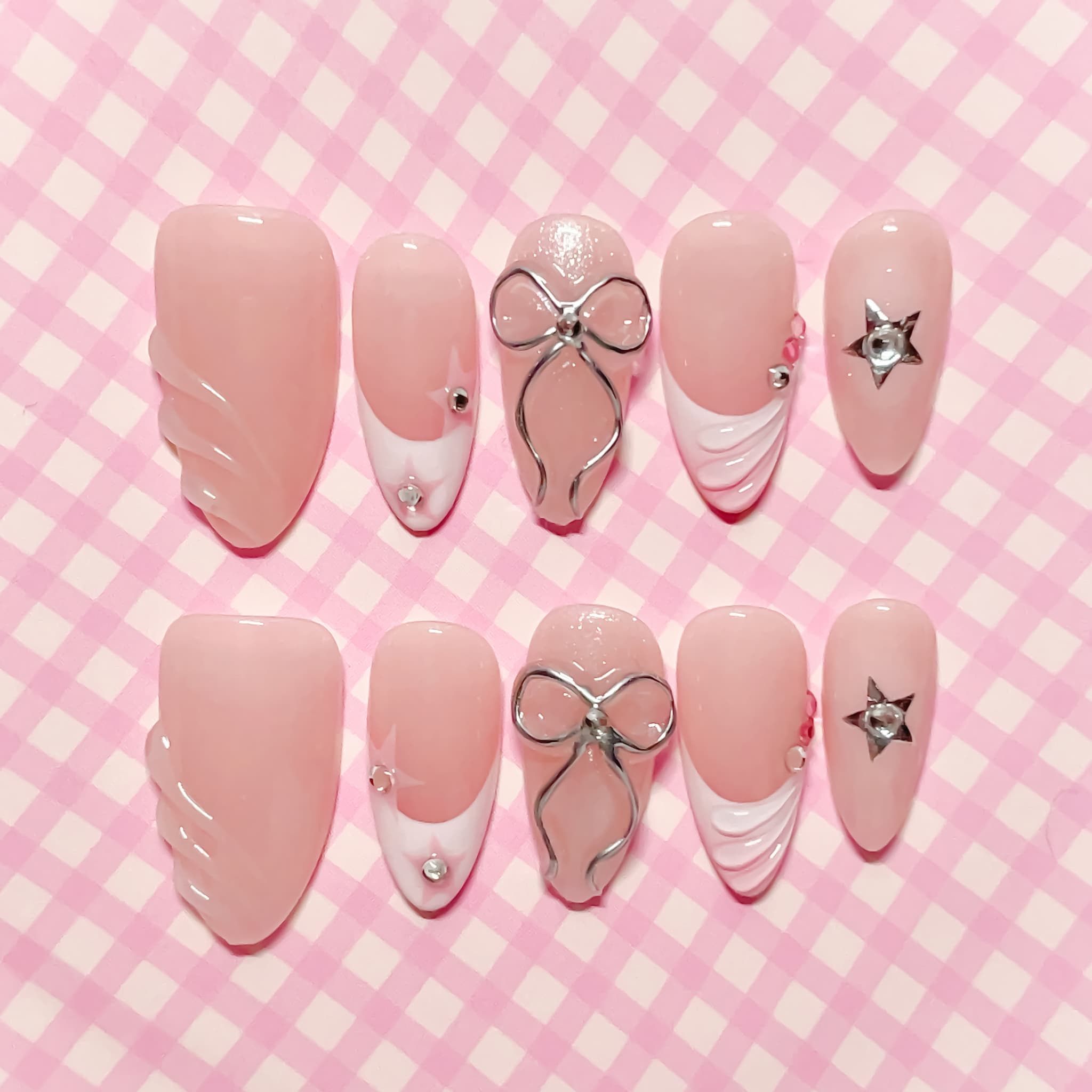 medium length light pink almond press on nails with bows and stars