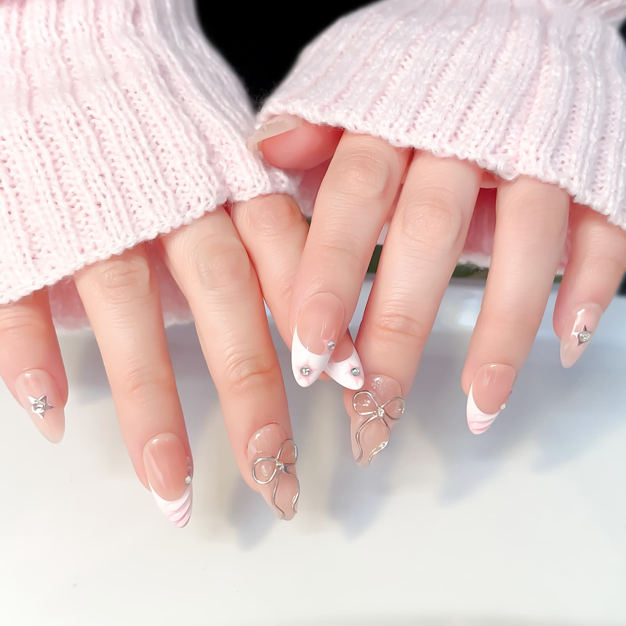 medium length light pink almond press on nails with bows and stars