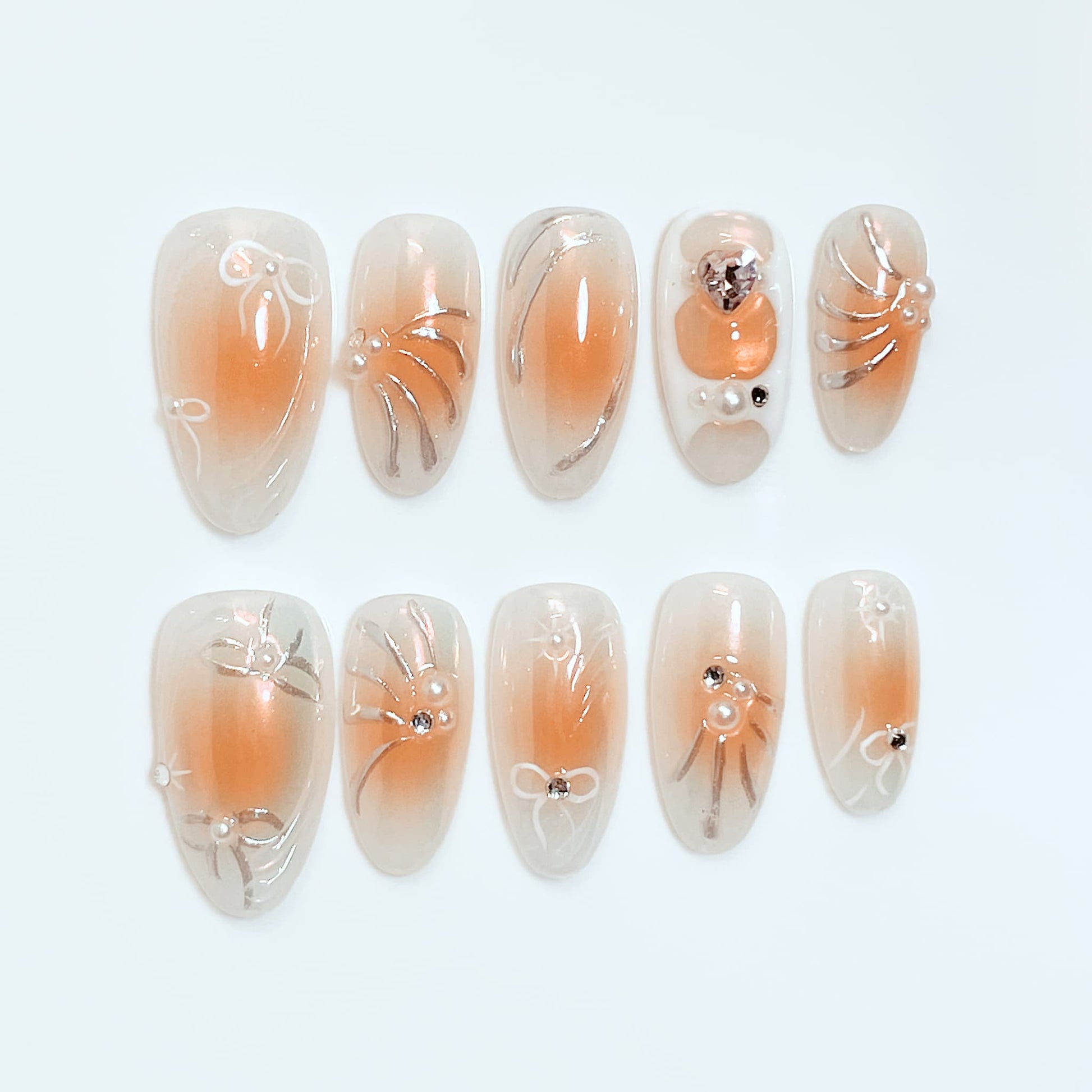 medium length orange almond press on nails with bow and pearl design