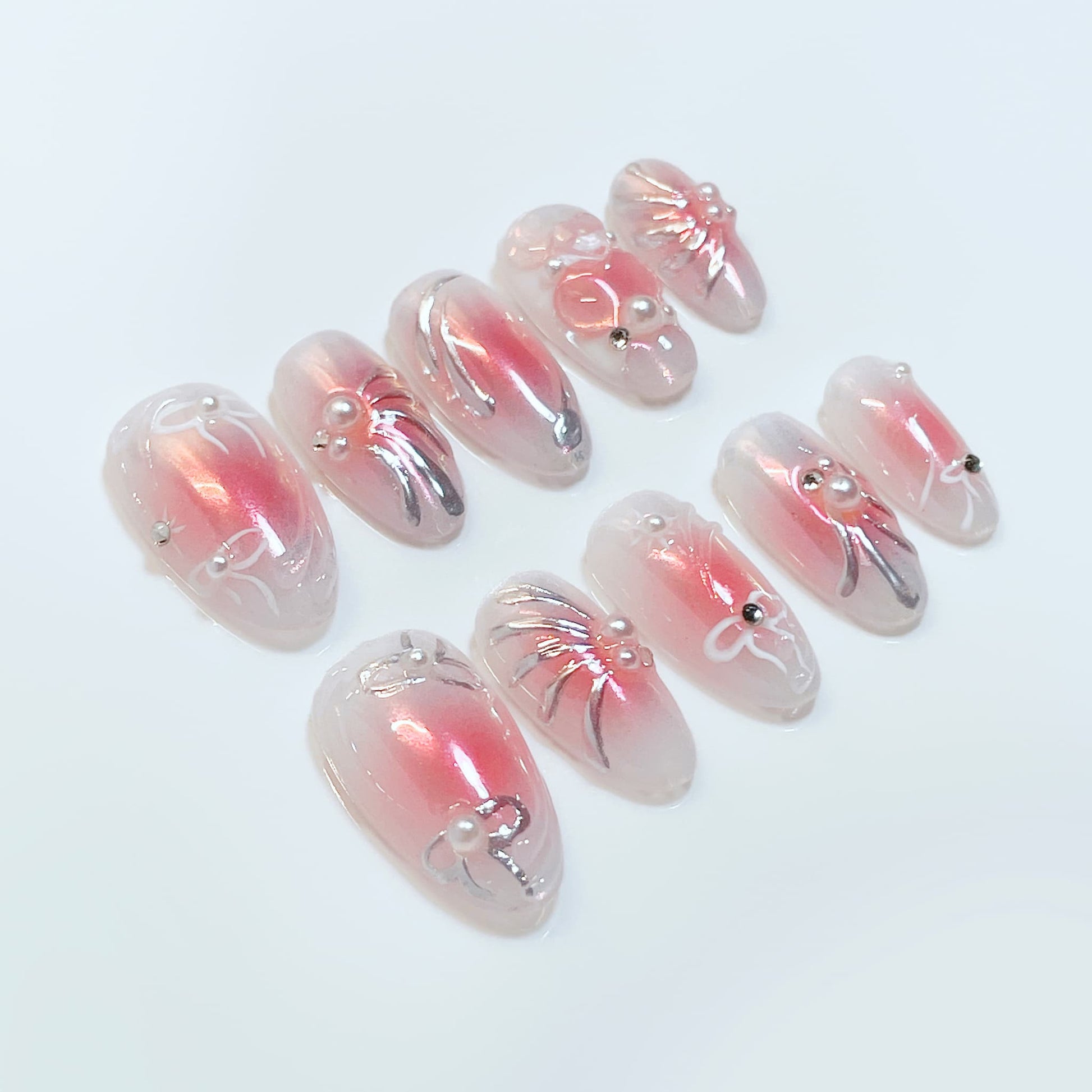 medium length pink almond press on nails with bow and pearl design