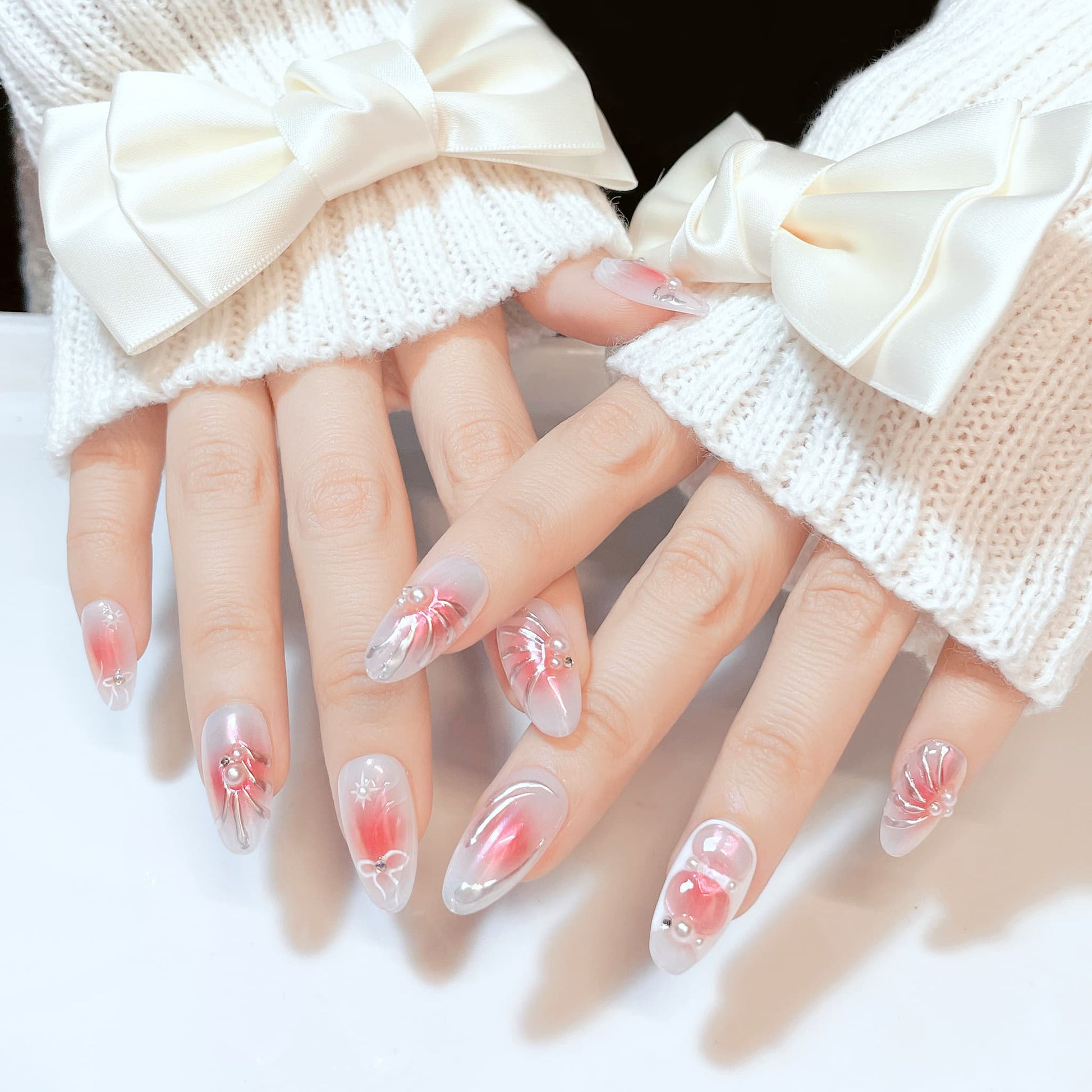 medium length pink almond press on nails with bow and pearl design