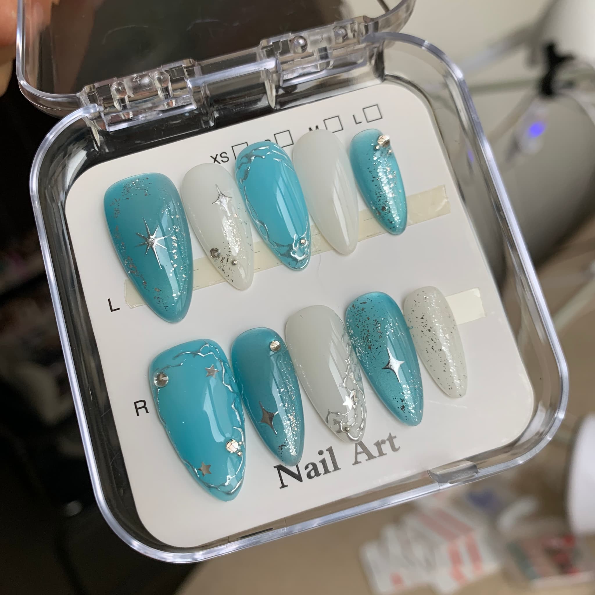 celestial blue glossy medium almond press on nails with stars , glitter and swirls motifs