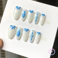 oceanic white glossy almond press on nails with fish and eye motifs