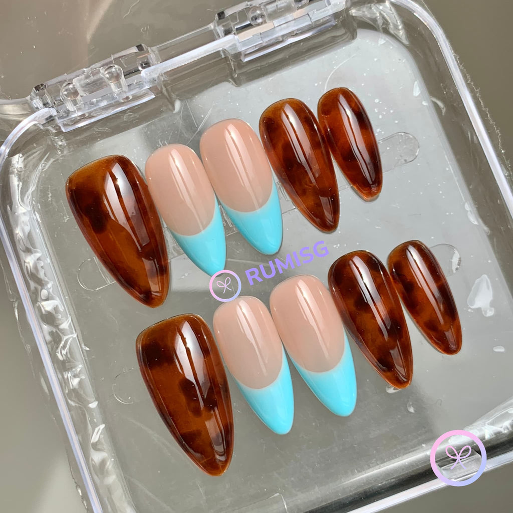 animal print brown glossy medium almond press on nails with tortoiseshell and a blue french tip