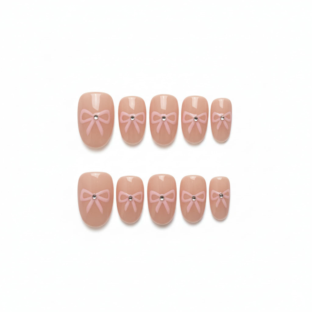 coquette nude glossy short oval press on nails with pink bows and rhinestone motifs