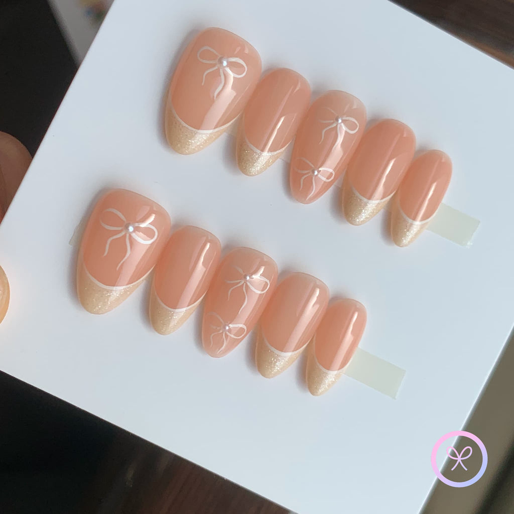 minimalist nude glossy short almond press on nails with mini white bows and lined french tip