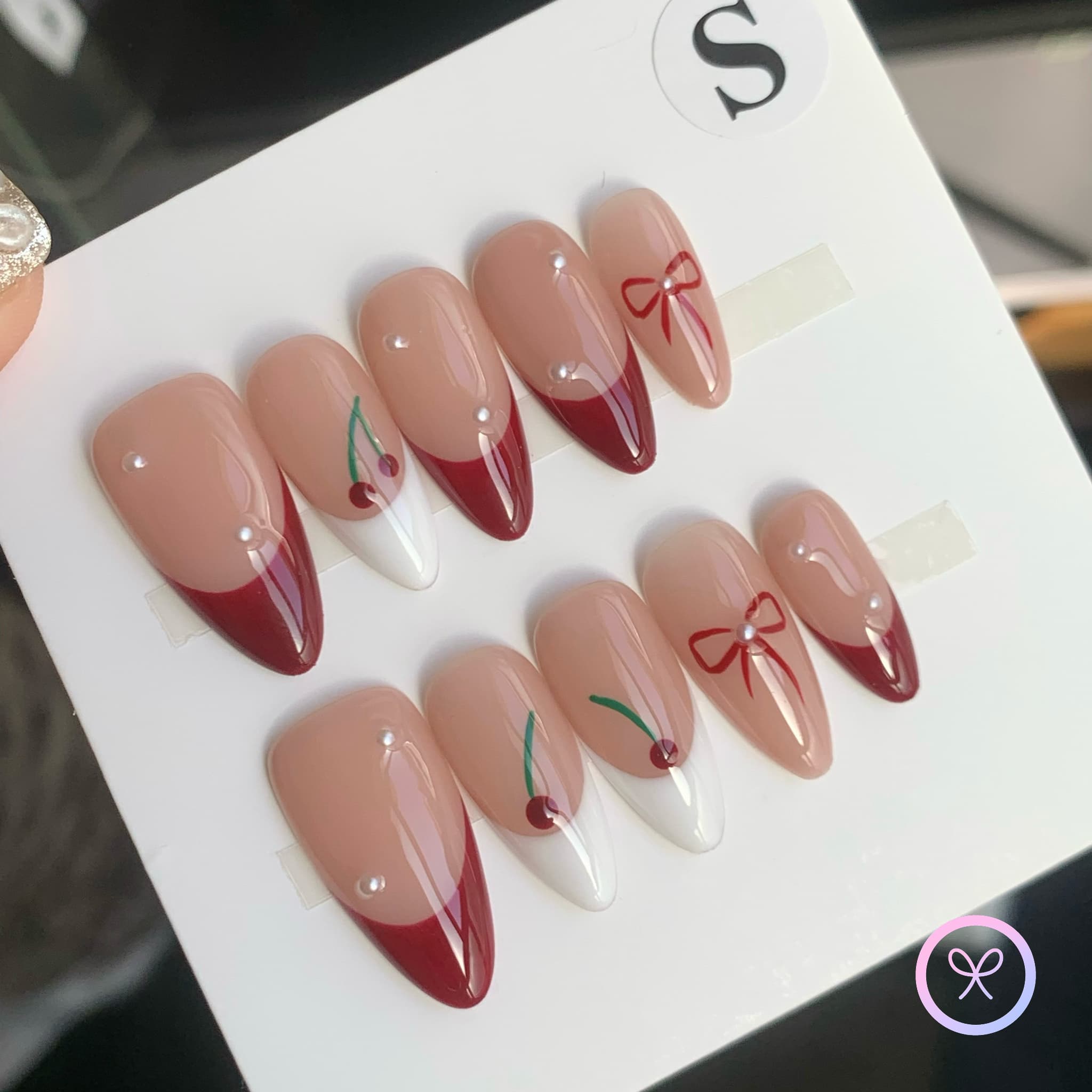 minimalist nude glossy medium almond press on nails with cherry and pearls motif