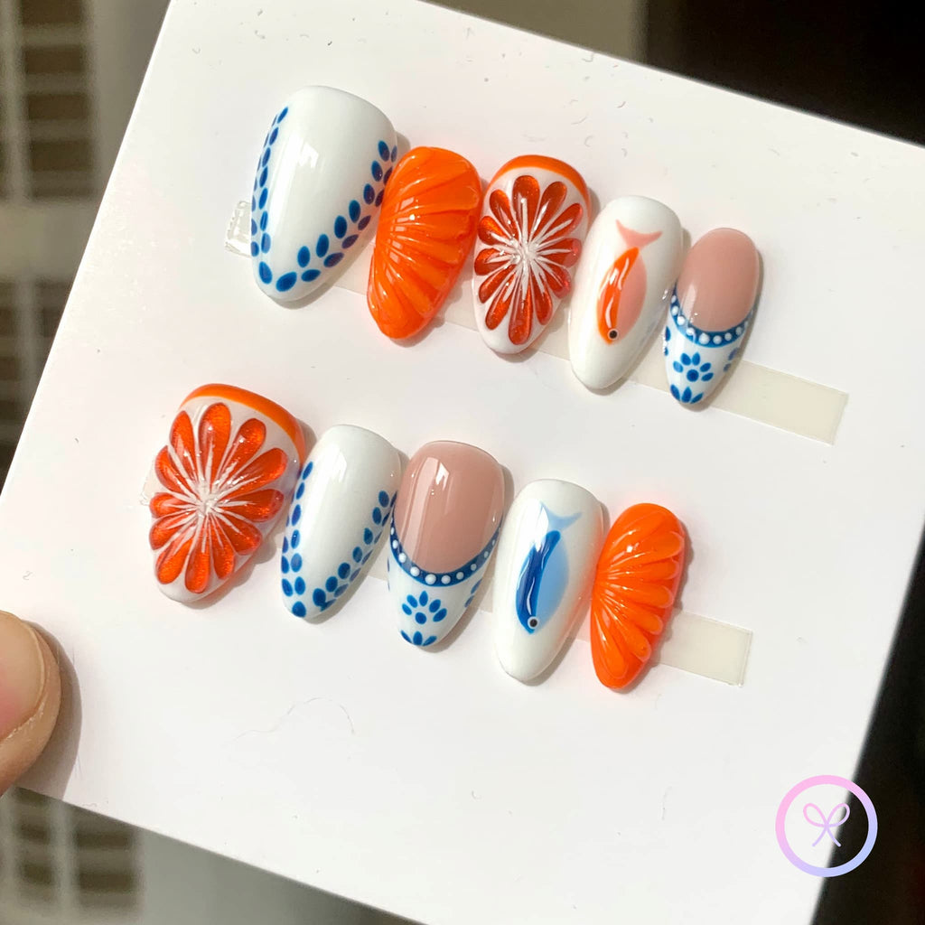 oceanic orange glossy short almond press on nails with tuna and salmon and citrus motifs