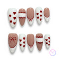 coquette nude glossy medium almond press on nails with heart shape motifs and lace and bows