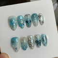 y2k blue glossy short almond press on nails with heart motifs and butterfly wings