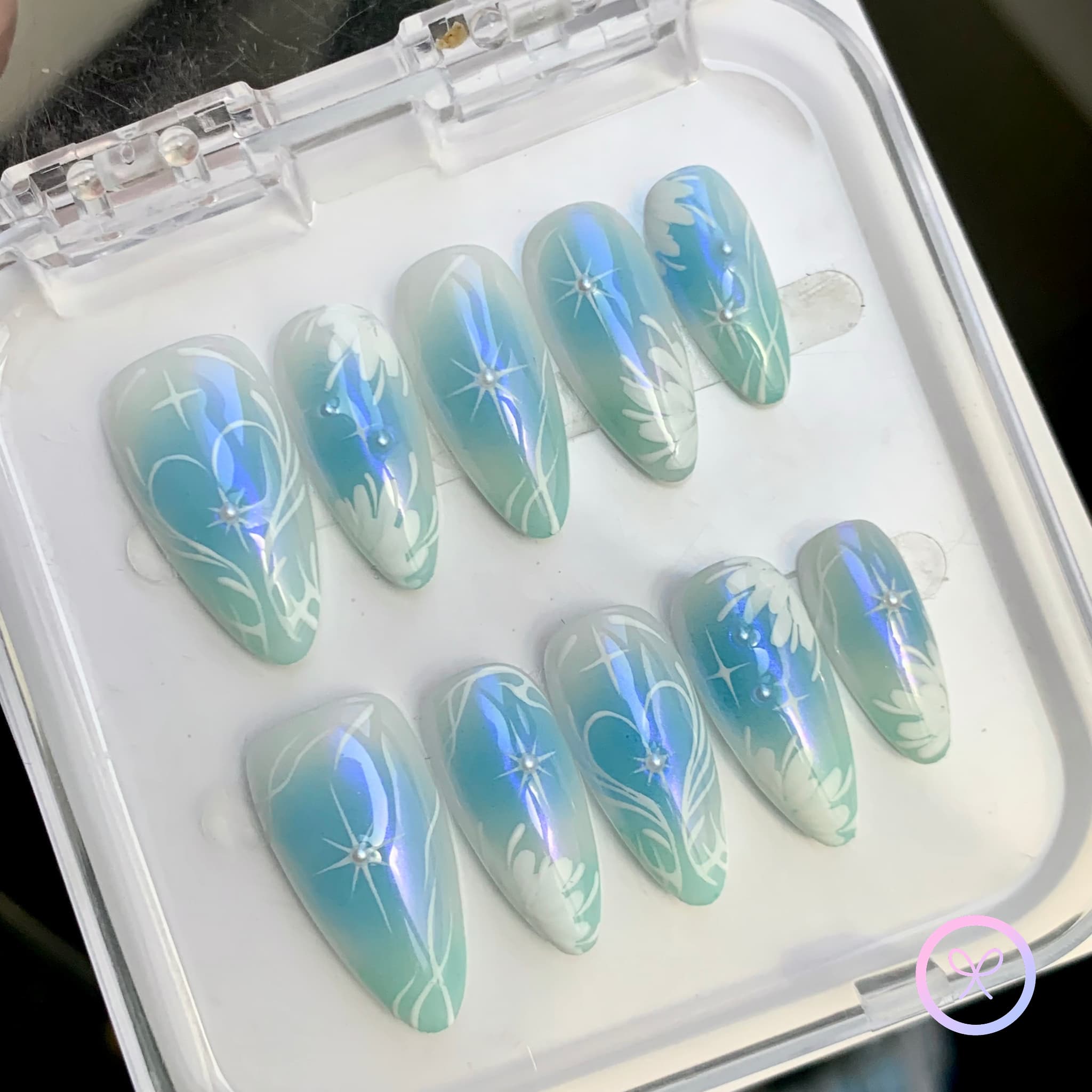 elegant blue iridescent medium almond press on nails with hearts and celestial motifs